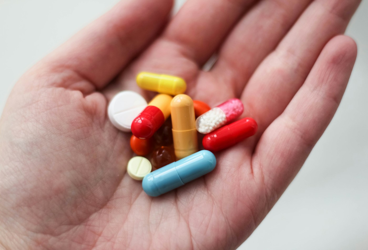Médicaments photographiés dans une main. Illustration générale de la tolérance, sans identification d’un traitement de l’obésité.