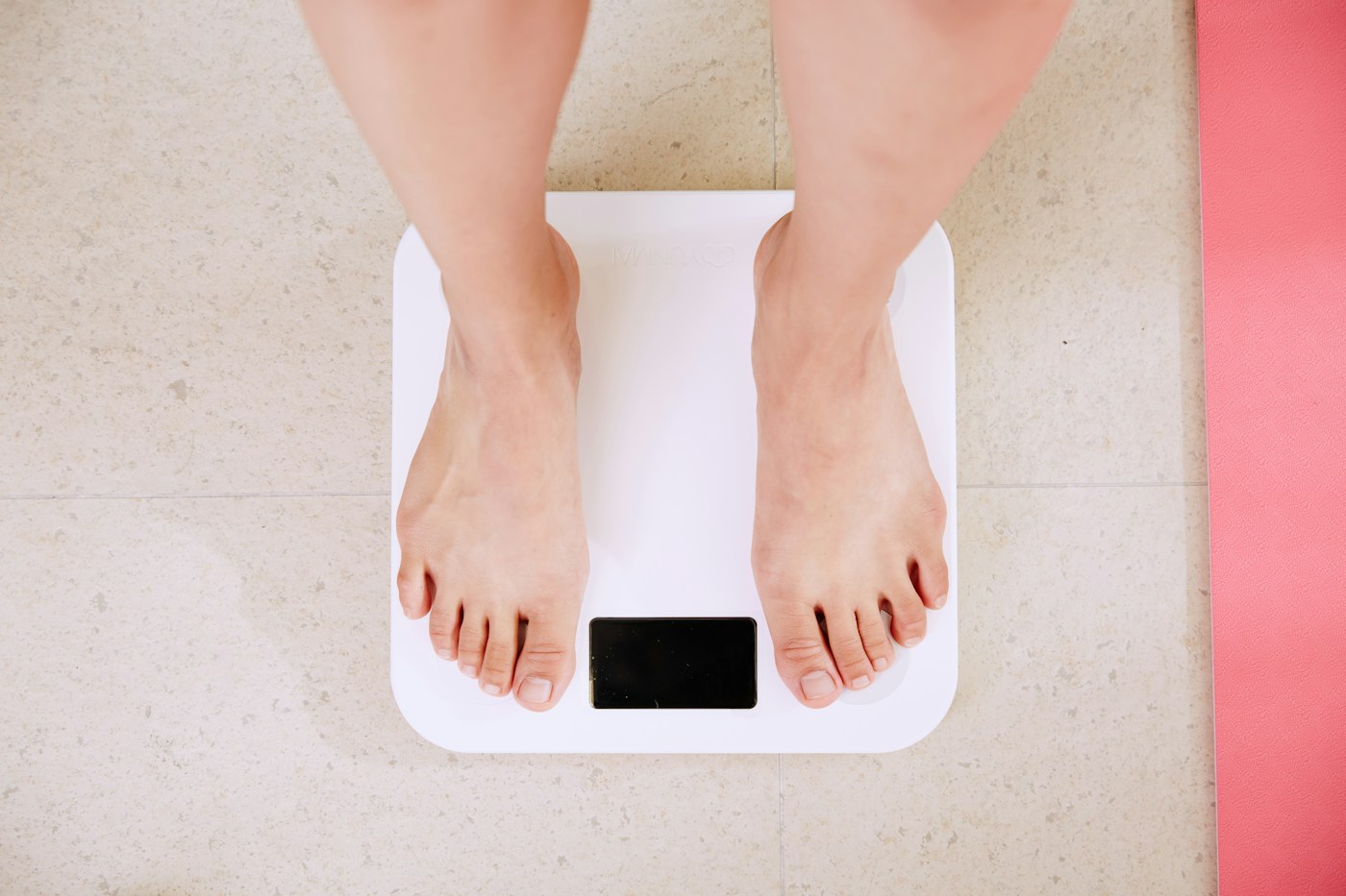 Pesée sur une balance. Illustration d’une mesure qui ne résume pas à elle seule le bilan de santé.