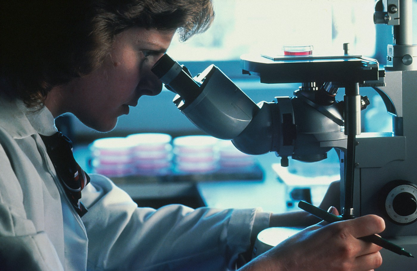 Travail au microscope dans un laboratoire. Photographie d’illustration de la recherche en cancérologie.